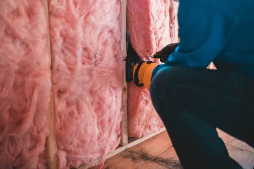 Insulation being fitted into a wall cavity on a Tampa Bay job